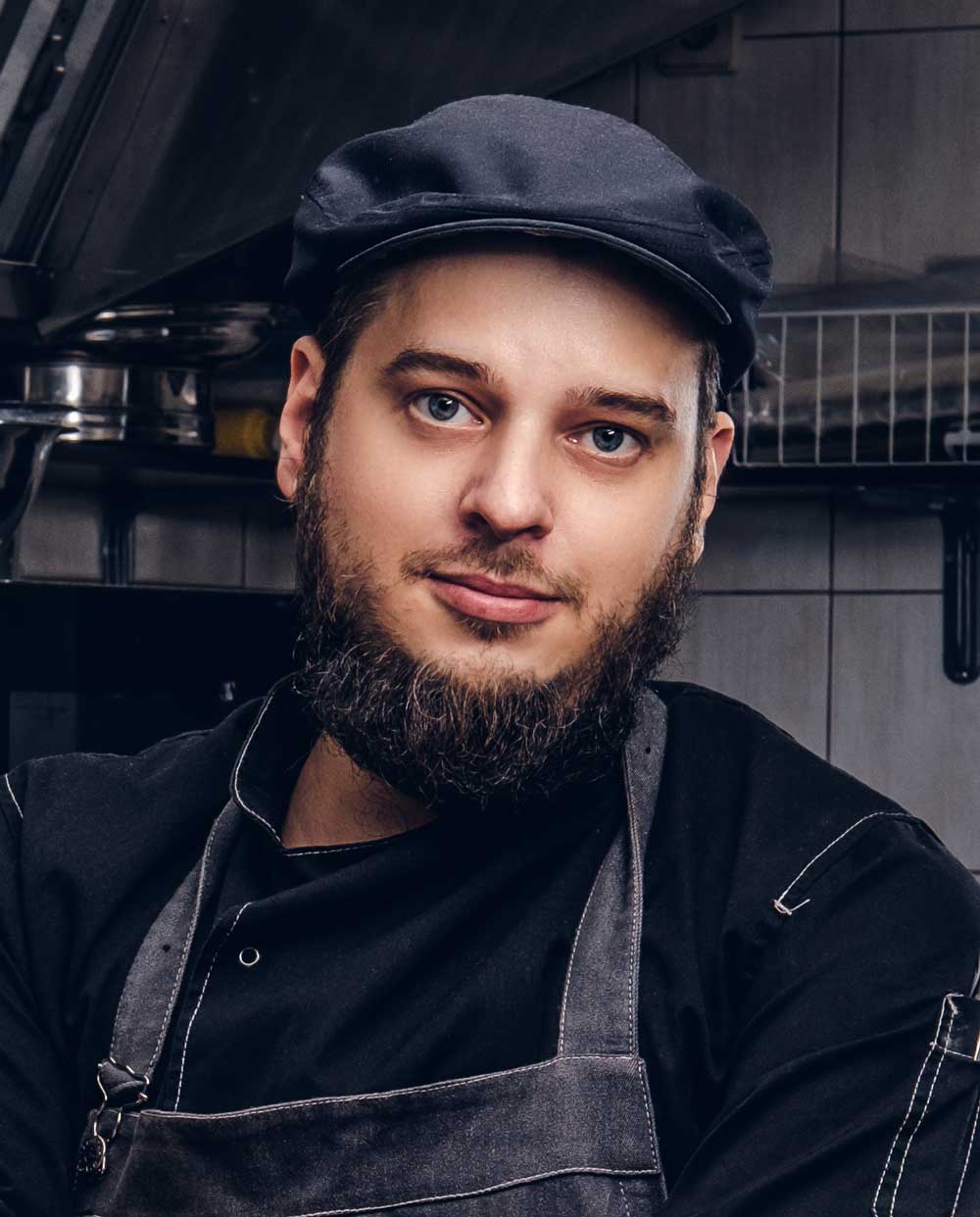 bearded-cook-in-black-uniform-and-hat-holds-knife-BMEASJV.jpg